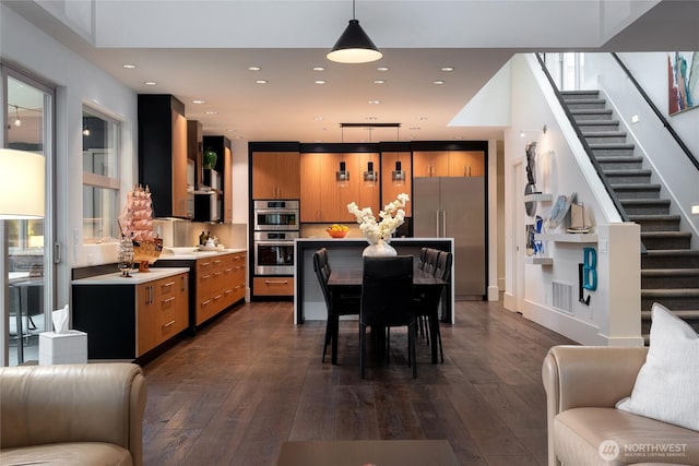 11116 SE 4th St, Bellevue, WA 98004 - kitchen featuring brown cabinetry, stainless steel appliances, dark wood-type flooring, and light countertops