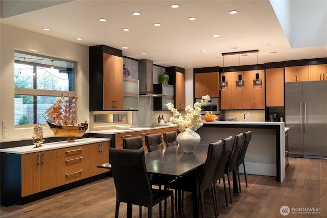 11116 SE 4th St, Bellevue, WA 98004 - kitchen with wall chimney exhaust hood, hardwood / wood-style flooring, light countertops, and appliances with stainless steel finishes