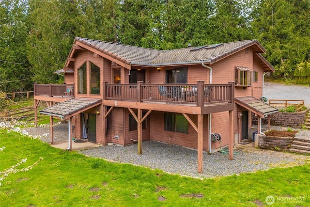 37902 278th Ave SE, Enumclaw, WA 98022 - back of property featuring a lawn, a tiled roof, a view of trees, a patio area, and a deck