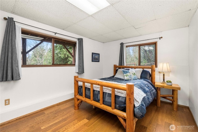 37902 278th Ave SE, Enumclaw, WA 98022 - bedroom featuring baseboards, multiple windows, a drop ceiling, and wood finished floors