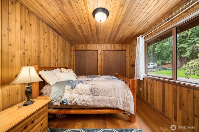 37902 278th Ave SE, Enumclaw, WA 98022 - bedroom featuring wooden ceiling, wooden walls, wood finished floors, and visible vents