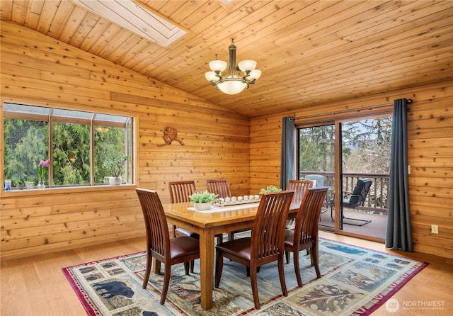 37902 278th Ave SE, Enumclaw, WA 98022 - dining room featuring a notable chandelier, wooden ceiling, wood walls, light wood-style floors, and vaulted ceiling with skylight