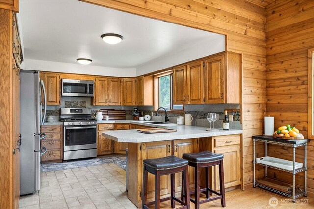 37902 278th Ave SE, Enumclaw, WA 98022 - kitchen featuring stainless steel appliances, a sink, a peninsula, light countertops, and tasteful backsplash