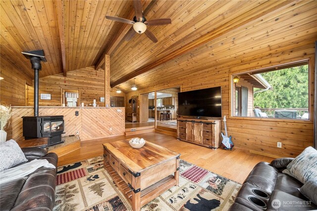 37902 278th Ave SE, Enumclaw, WA 98022 - living area with a wood stove, wood walls, ceiling fan, and vaulted ceiling with beams