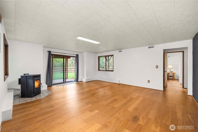 37902 278th Ave SE, Enumclaw, WA 98022 - unfurnished living room featuring a wood stove, light wood-style flooring, and visible vents
