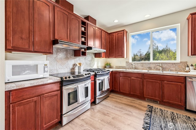 kitchen featuring appliances with stainless steel finishes, a sink, visible vents, and under cabinet range hood