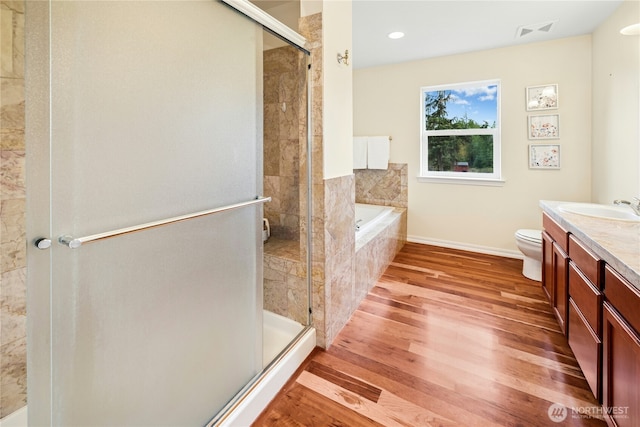 full bath featuring visible vents, a shower stall, vanity, and wood finished floors