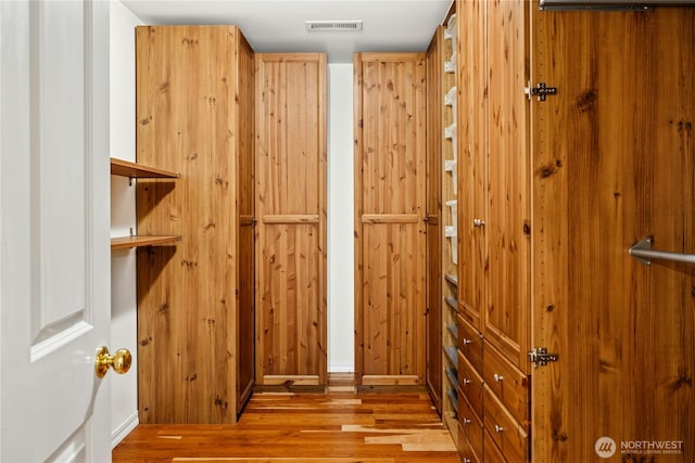 walk in closet with wood finished floors and visible vents