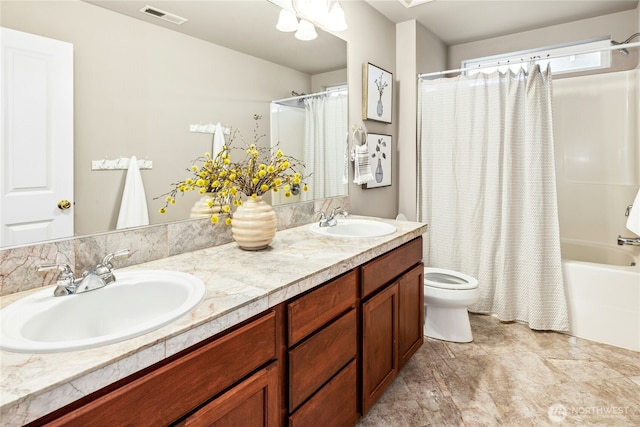 full bath with toilet, double vanity, a sink, and visible vents
