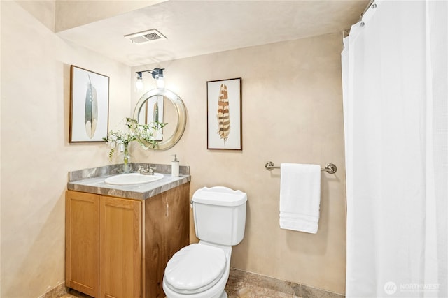 bathroom with vanity, visible vents, baseboards, and toilet