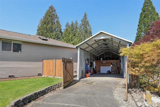 exterior space featuring concrete driveway, a gate, crawl space, fence, and a yard