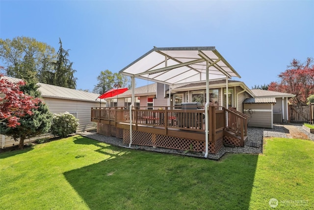 rear view of property with a deck and a yard