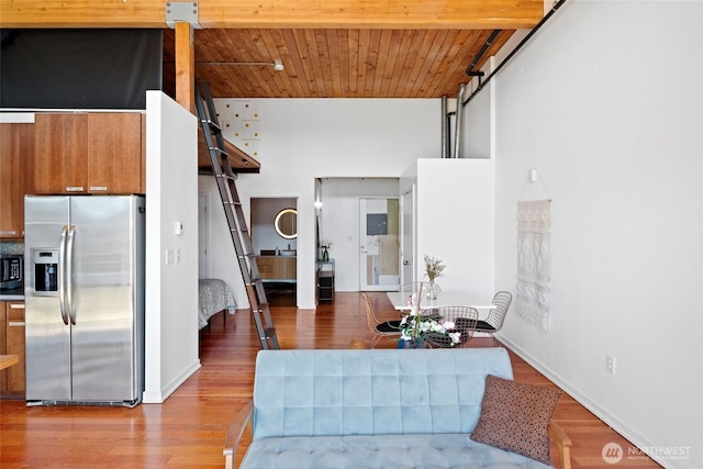 1408 12th Ave Unit 507, Seattle, WA 98122 - kitchen with stainless steel fridge, wood finished floors, brown cabinetry, baseboards, and wooden ceiling