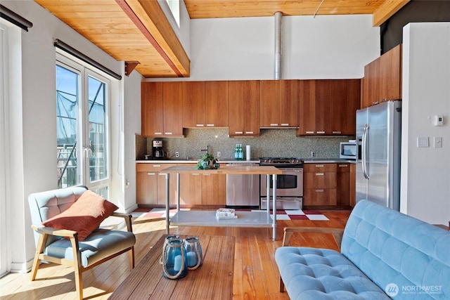 1408 12th Ave Unit 507, Seattle, WA 98122 - kitchen featuring stainless steel appliances, brown cabinets, hardwood / wood-style flooring, decorative backsplash, and wood ceiling