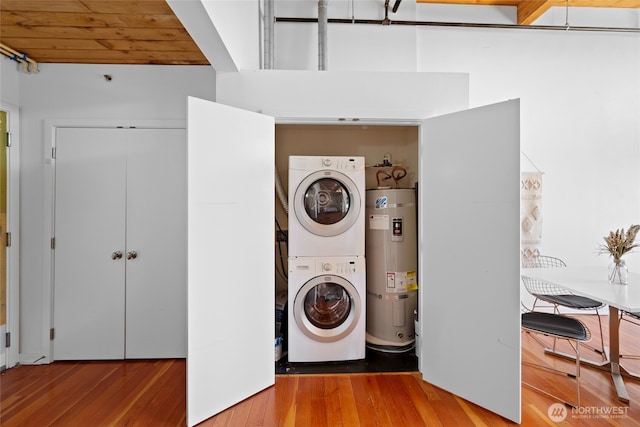 1408 12th Ave Unit 507, Seattle, WA 98122 - laundry area with secured water heater, stacked washing machine and dryer, and hardwood / wood-style flooring