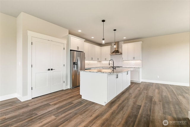 kitchen featuring stainless steel refrigerator with ice dispenser, dark wood-style flooring, white cabinets, and wall chimney range hood