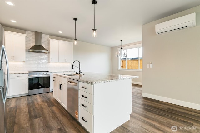 kitchen featuring a wall unit AC, appliances with stainless steel finishes, dark wood finished floors, a sink, and wall chimney exhaust hood