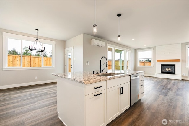 kitchen featuring dark wood-style flooring, an AC wall unit, a sink, and dishwasher