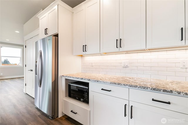 kitchen featuring light stone countertops, black microwave, stainless steel fridge with ice dispenser, dark wood finished floors, and recessed lighting