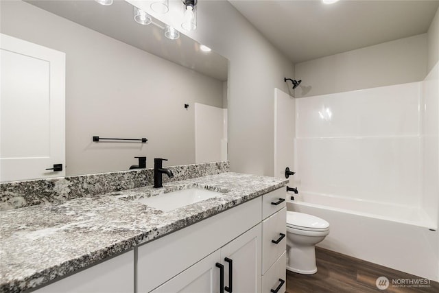 full bath with vanity,  shower combination, wood finished floors, and toilet