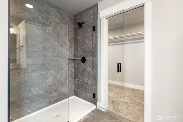 bathroom with a walk in closet and a stall shower