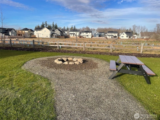 view of home's community featuring a lawn, fence, and a residential view