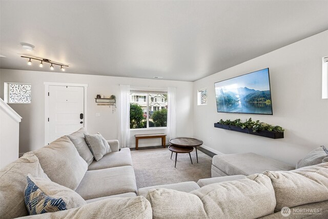 living area with baseboards and light carpet