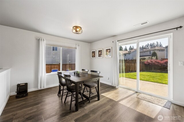 dining space with visible vents, dark wood finished floors, and baseboards
