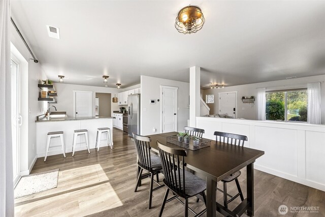 dining room featuring visible vents and wood finished floors