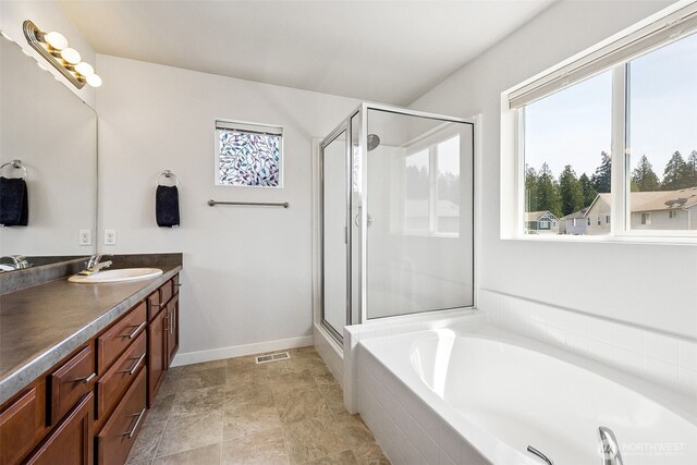 bathroom with vanity, a garden tub, visible vents, baseboards, and a stall shower