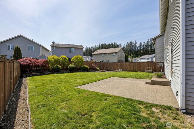 view of yard with a residential view, a fenced backyard, and a patio area