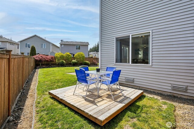 view of yard with a deck, outdoor dining area, and a fenced backyard