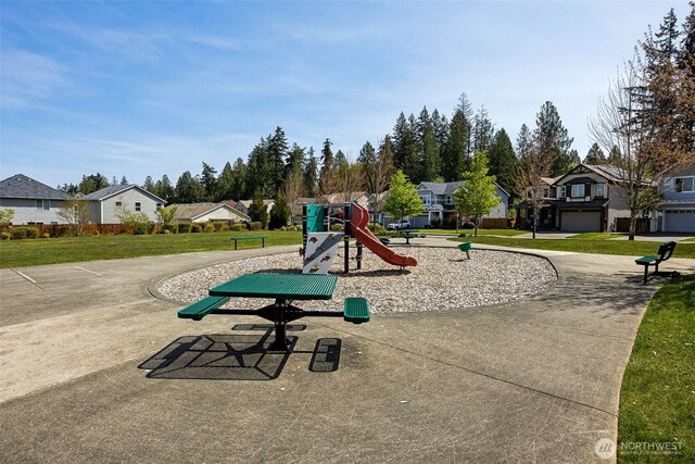 communal playground with a yard and a residential view
