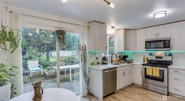 kitchen with light countertops, tasteful backsplash, appliances with stainless steel finishes, and a sink