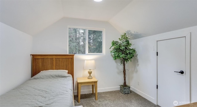 bedroom with vaulted ceiling, carpet flooring, and baseboards