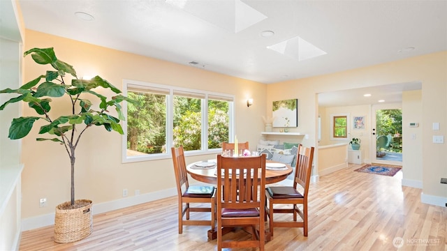 4657 Island Ave NE, Bainbridge Island, WA 98110 - dining room with a skylight, light wood-style flooring, and baseboards