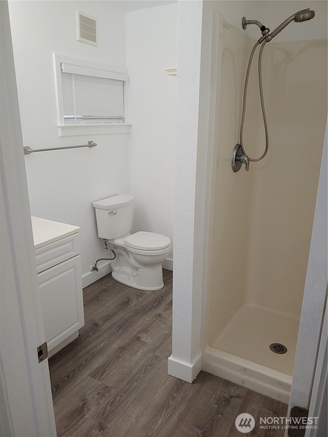 1700 California Ave S, Long Beach, WA 98631 - bathroom featuring vanity, a stall shower, toilet, visible vents, and wood finished floors