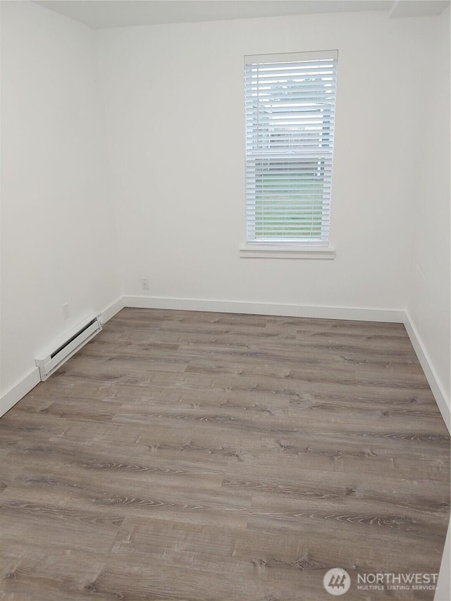 1700 California Ave S, Long Beach, WA 98631 - spare room featuring wood finished floors, a baseboard heating unit, and baseboards