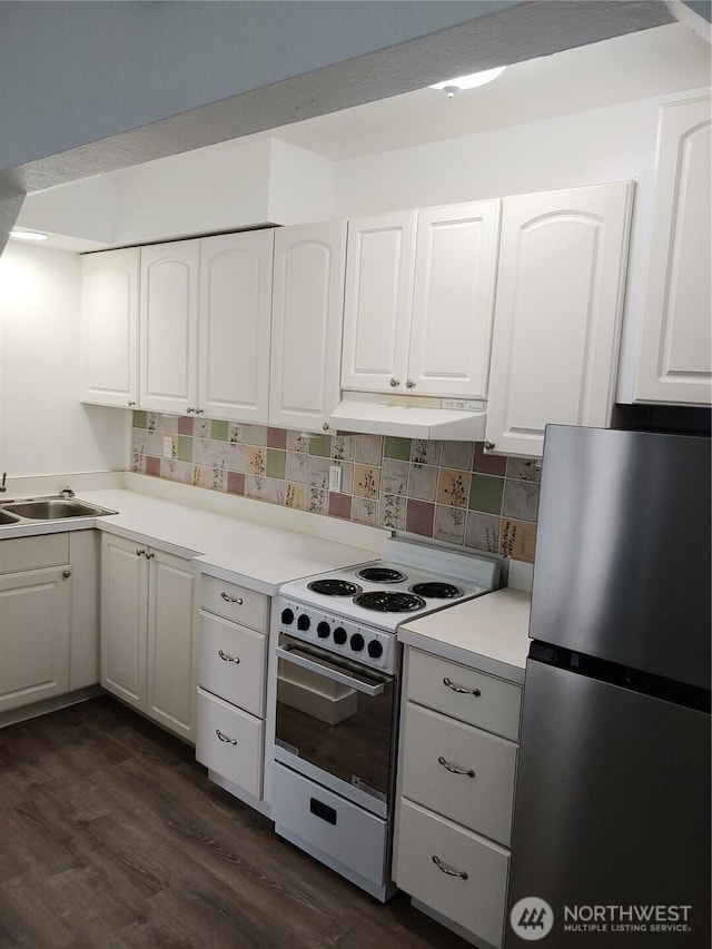 1700 California Ave S, Long Beach, WA 98631 - kitchen featuring dark wood-style flooring, electric range, freestanding refrigerator, white cabinets, and under cabinet range hood