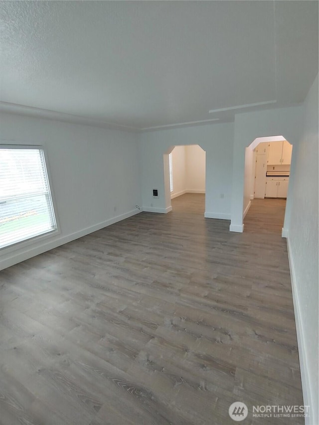 1700 California Ave S, Long Beach, WA 98631 - additional living space with baseboards, arched walkways, and wood finished floors