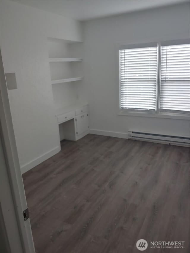 1700 California Ave S, Long Beach, WA 98631 - empty room with baseboards, wood finished floors, and baseboard heating