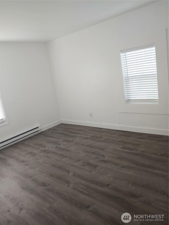1700 California Ave S, Long Beach, WA 98631 - unfurnished room with a baseboard heating unit, dark wood-type flooring, and baseboards