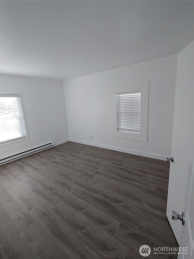 1700 California Ave S, Long Beach, WA 98631 - unfurnished room featuring a baseboard radiator, baseboards, and dark wood-style floors