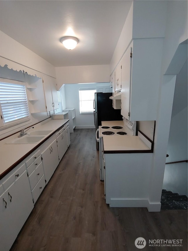1700 California Ave S, Long Beach, WA 98631 - kitchen with dark wood finished floors, ventilation hood, white cabinets, a sink, and electric stove