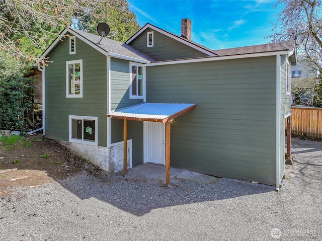 view of front of house featuring fence and a chimney