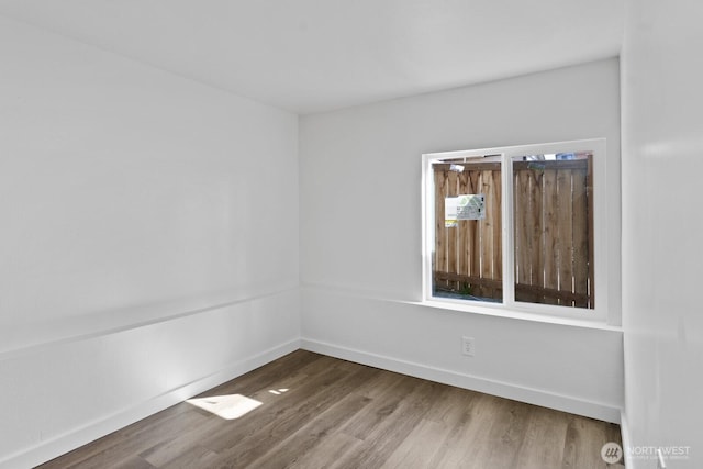 spare room with wood finished floors and baseboards