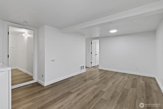 finished basement with washer / clothes dryer, visible vents, baseboards, and wood finished floors