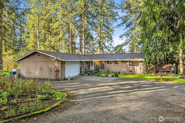 single story home featuring aphalt driveway, fence, and an attached garage