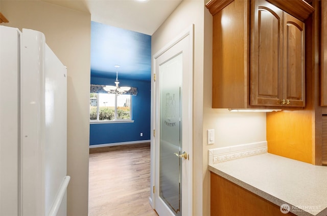 bathroom featuring wood finished floors, a chandelier, and baseboards