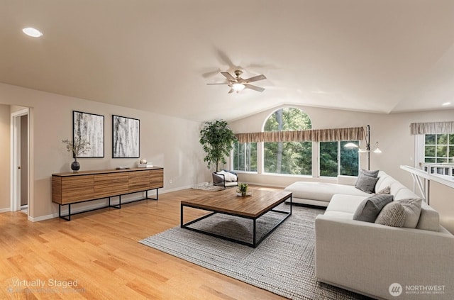 living room with light wood-style flooring, a ceiling fan, vaulted ceiling, and baseboards